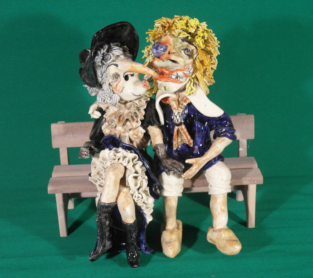 Basler Fasnachtsfigur Alti Dante und Waggis verliebt auf einer Bank