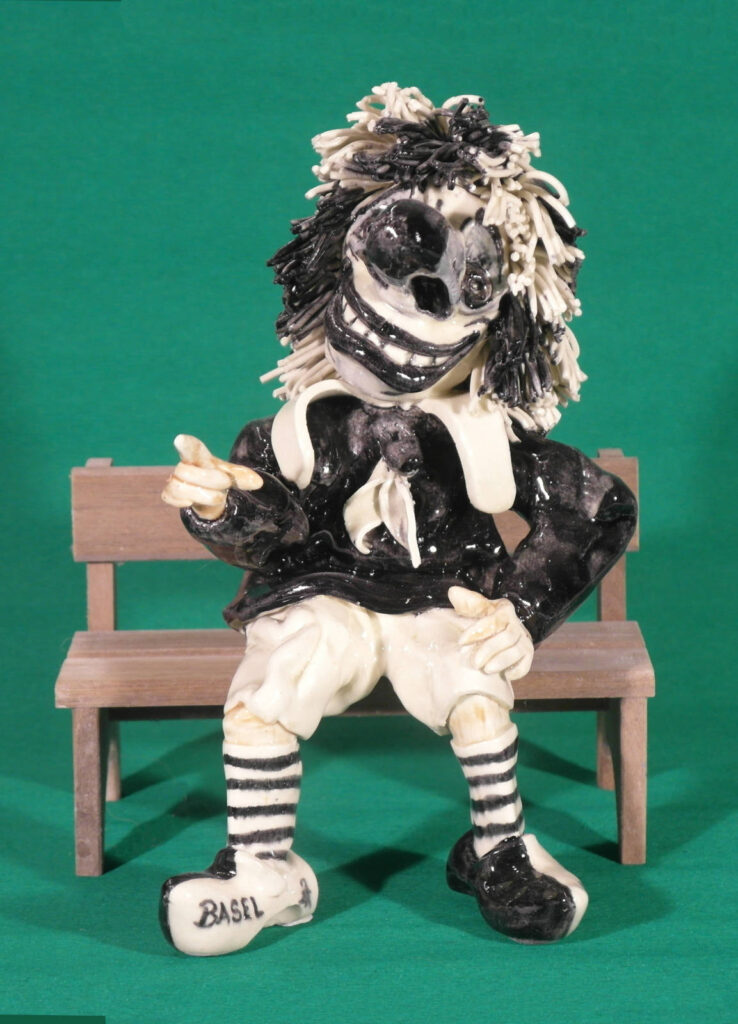 Basler Fasnachtsfigur Waggis schwarz und weiß auf Bank